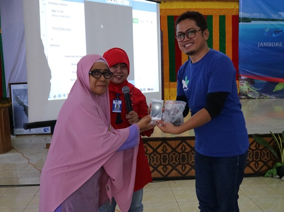 Regional Sales Manager Aceh, Trisna Gunawan menyerahkan seperangkat handset yang dilengkapi dengan aplikasi Nelayan Pintar (Nelpin kepada perwakilan nelayan di Sabang, Minggu (3/12/2017).  
